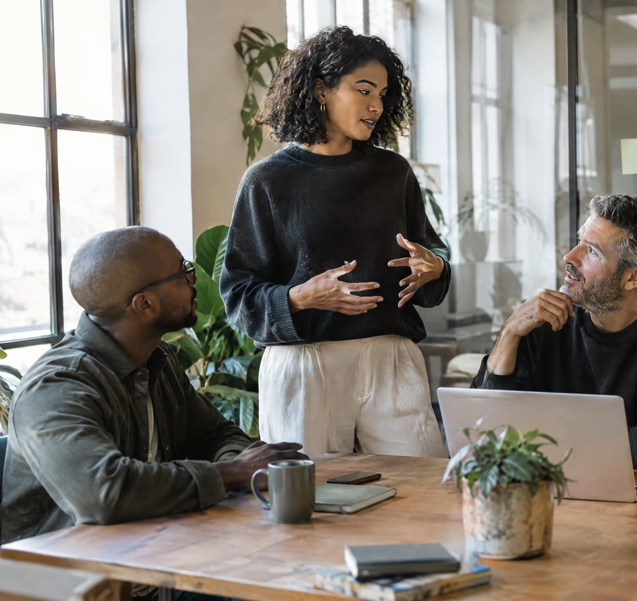 Colleagues talking around a table in a bright workspace