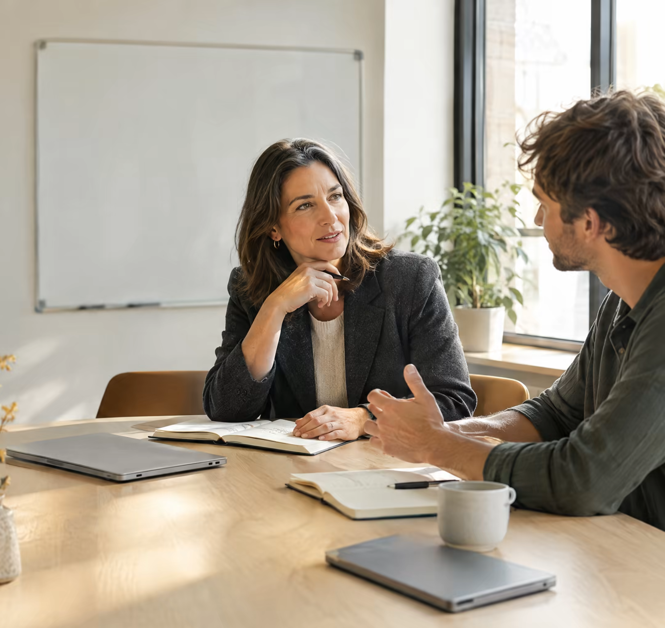Two colleagues talking across a meeting table